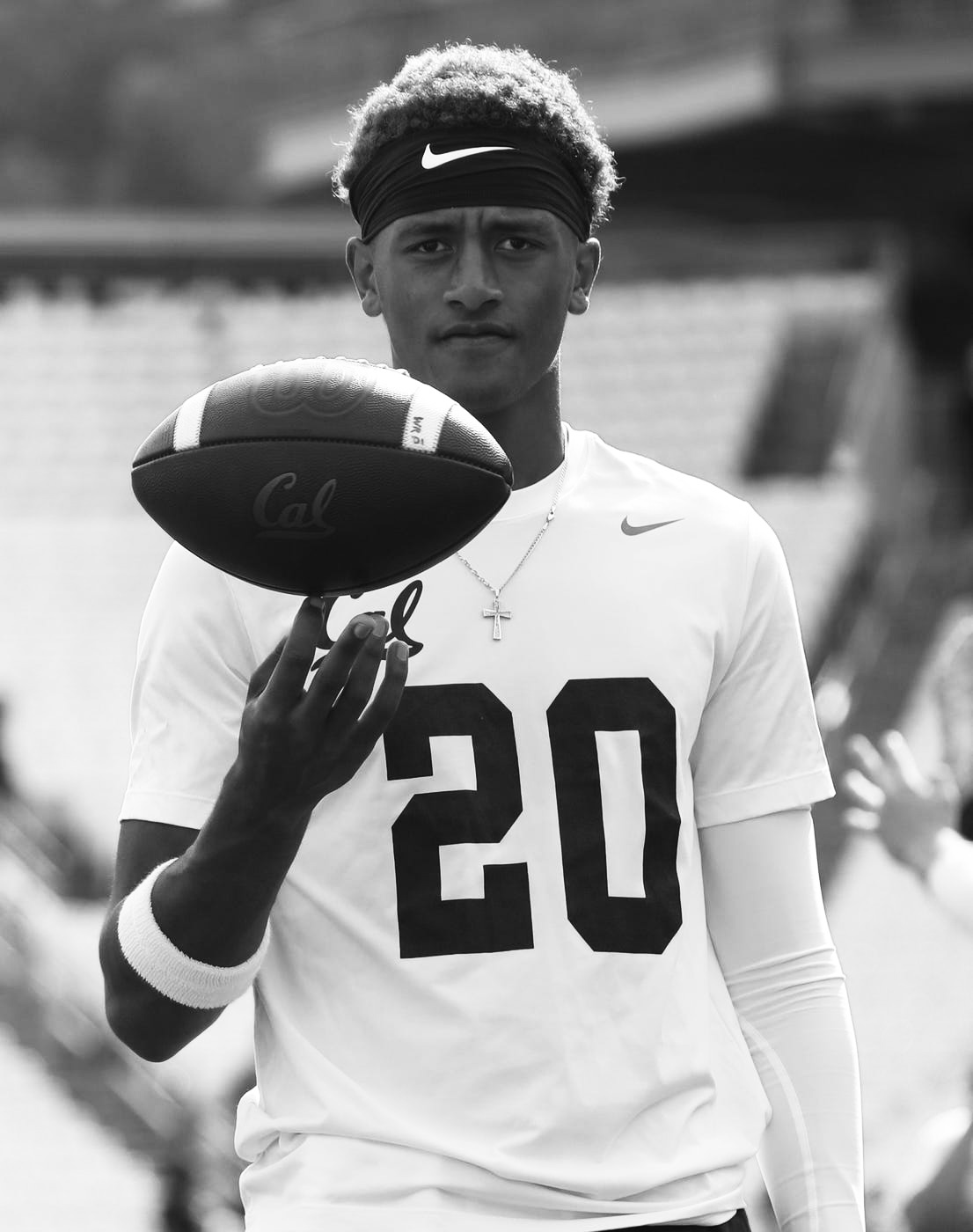Belay Brummel in his Cal No. 20 jersey holding a Cal football